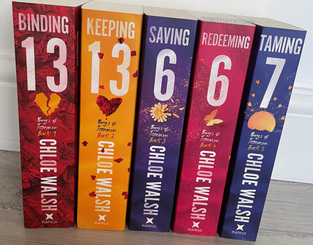 Photo of The Boys Of Tommen series all together - spines showing in different colours, red, yellow, purple, pink and blue against a white wall.